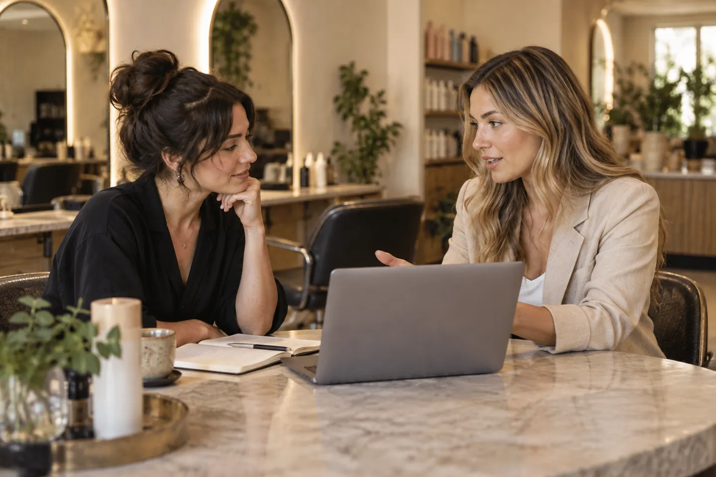 An owner and a booking-software demonstrator having a face-to-face trial discussion at a salon table
